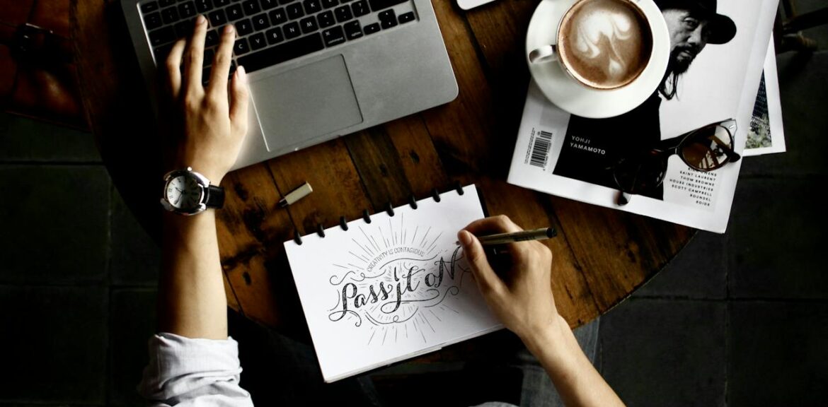 person sitting facing laptop computer with sketch pad