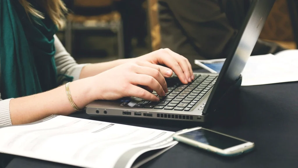 Free woman's hands typing laptop